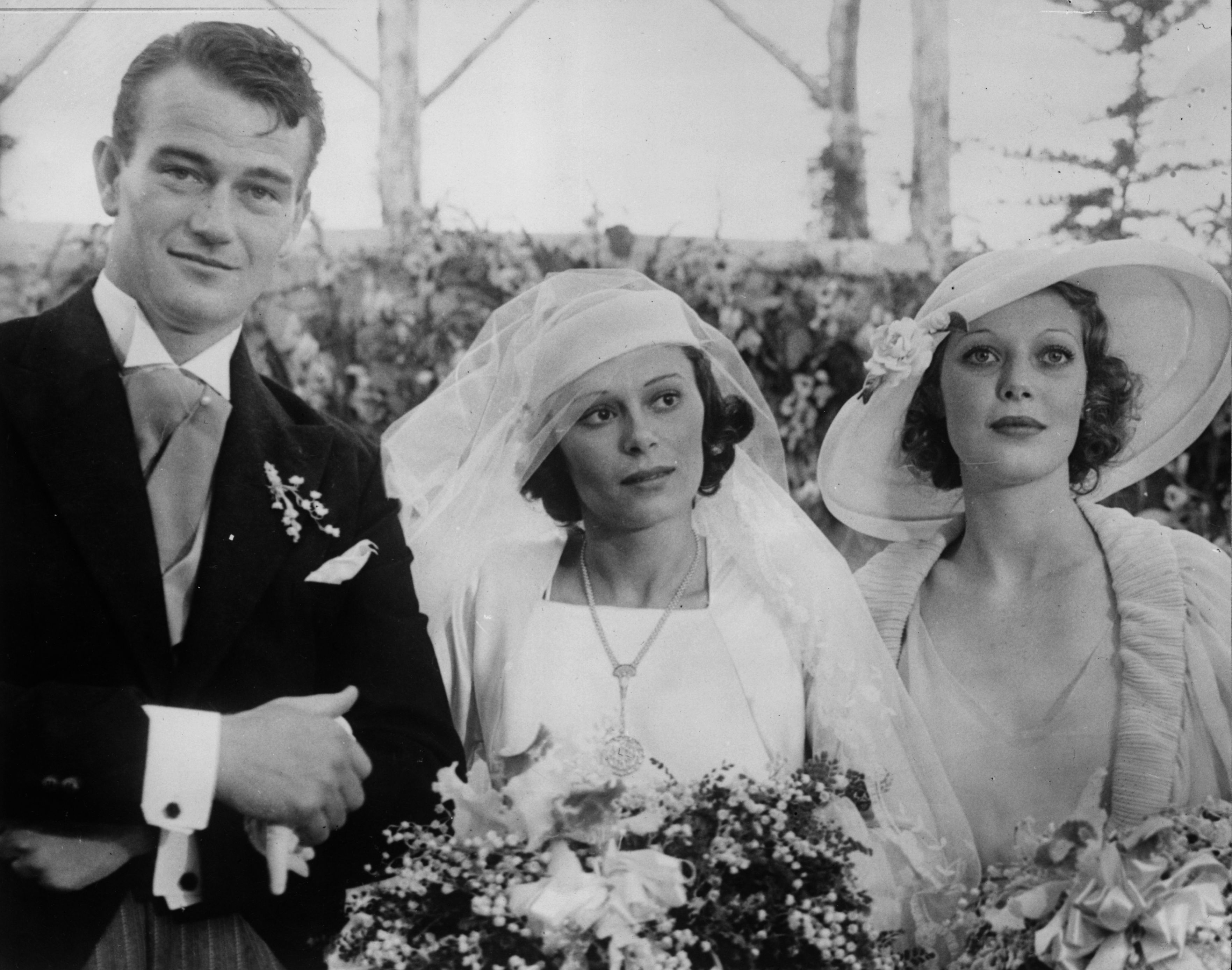 Film actor John Wayne on his wedding day with his wife Josephine Saenz and Loretta Young (1913 - 2000) | Source: Getty Images